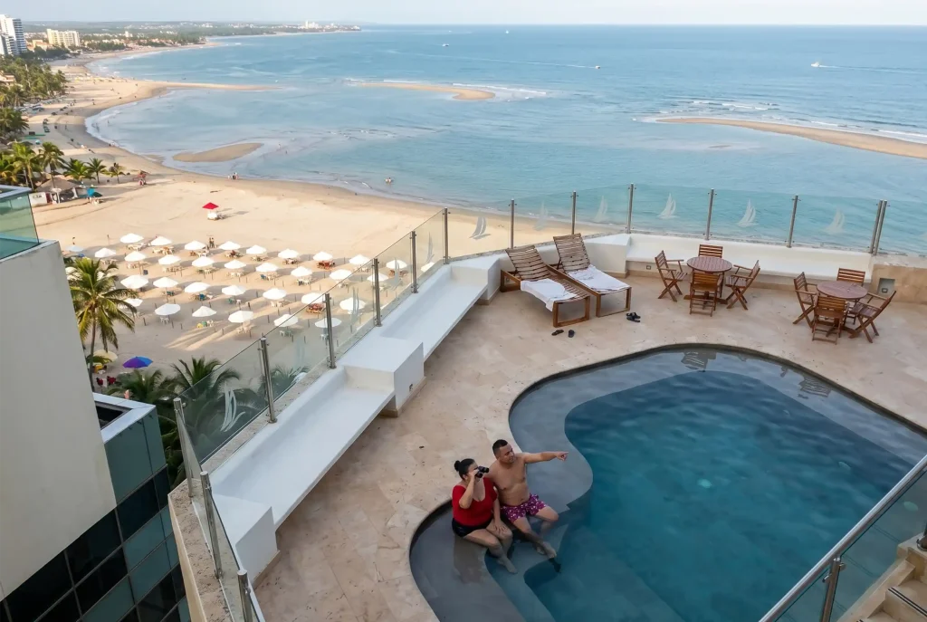 Pareja disfrutando en la piscina panorámica del último piso de un hotel frente a la playa en Cartagena.