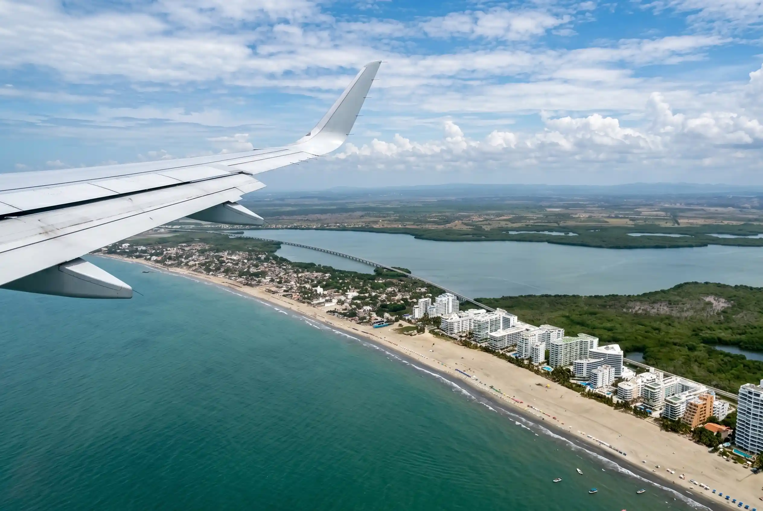 Aerial view of Bocagrande from an airplane arriving in Cartagena, showing beachfront hotels, sandy shores, and turquoise Caribbean waters