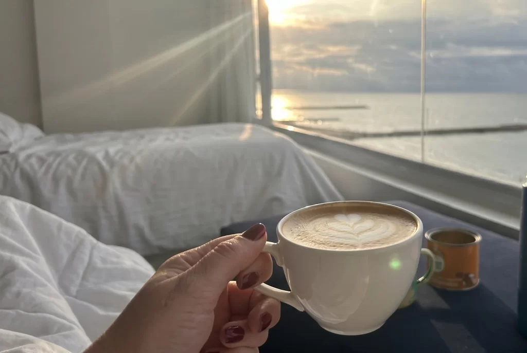 Latte art coffee in Hotel Regatta room with sunrise view over the Caribbean Sea in Cartagena.