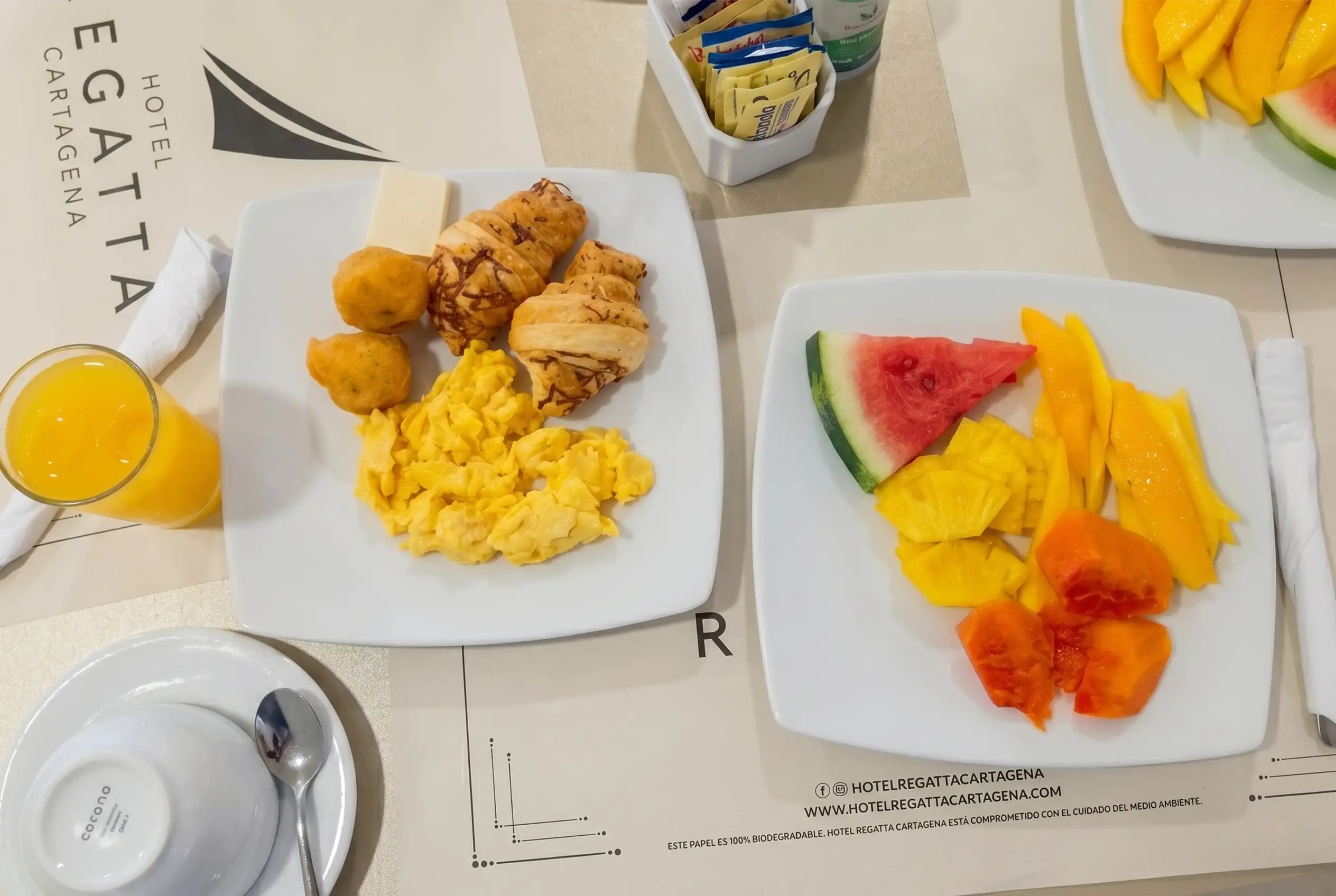 Desayuno incluido en el Hotel Regatta Cartagena con huevos, buñuelos, croissants y frutas tropicales.