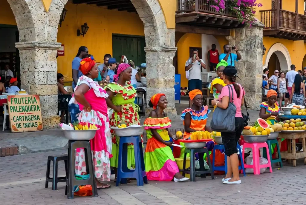 Palenqueras con trajes típicos vendiendo frutas tropicales en el centro histórico de Cartagena de Indias.