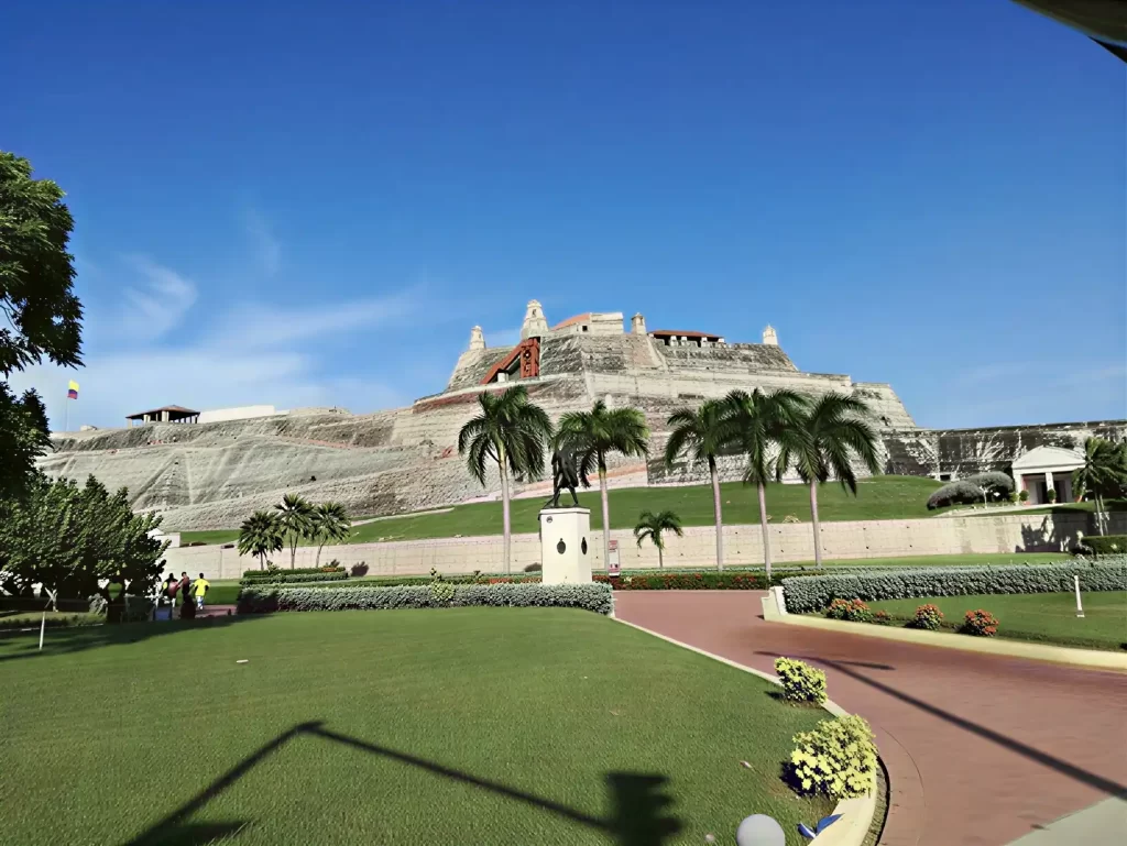 Front view of Castillo San Felipe de Barajas with colonial walls, royal palms and equestrian statue in Cartagena de Indias.