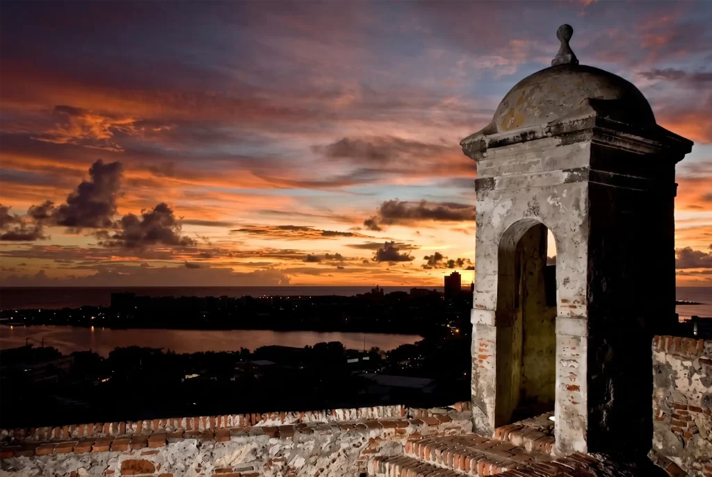 Garita colonial de las murallas de Cartagena al atardecer con vista panorámica de la bahía y la ciudad.