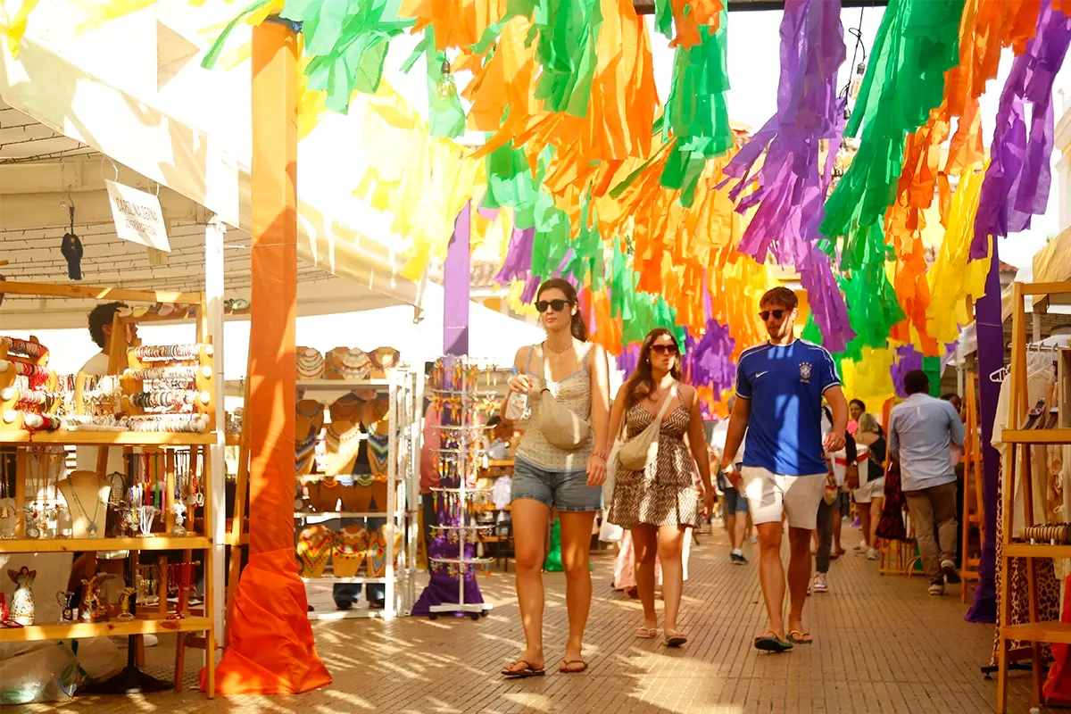 Tourists shopping for crafts at a colorful market in Cartagena
