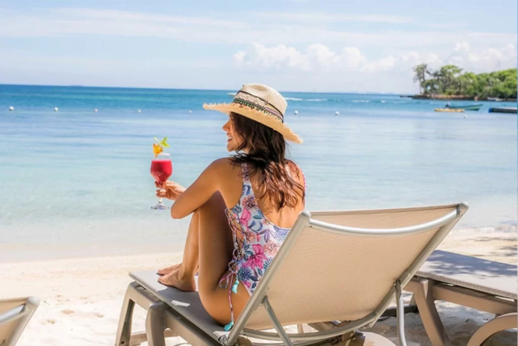 Woman relaxing alone on the beach with a cocktail in Cartagena

