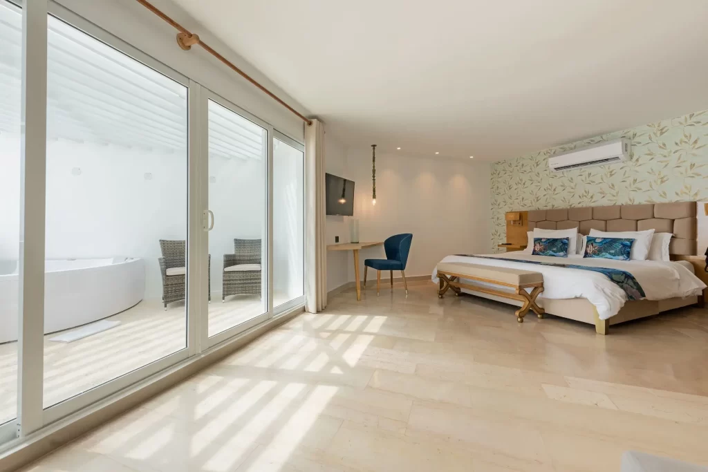 Lujosa habitación deluxe con cama king, área de trabajo y terraza privada con jacuzzi en el Hotel Regatta Cartagena.