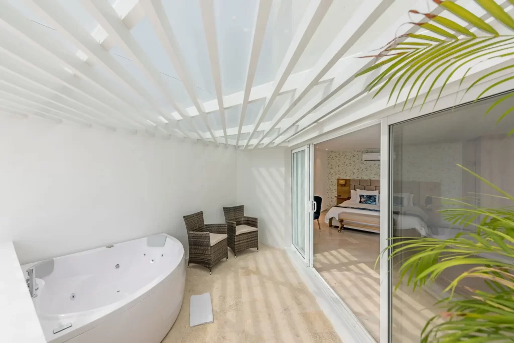 Terraza privada con jacuzzi hidromasaje y sillas tejidas conectada a la habitación deluxe del Hotel Regatta Cartagena.