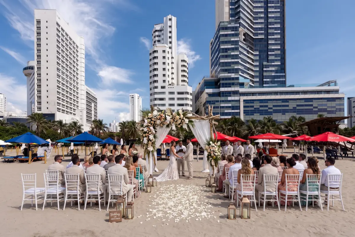 Pareja celebrando una ceremonia de bodas en cartagena hoteles salones sobre la playa frente a los edificios.