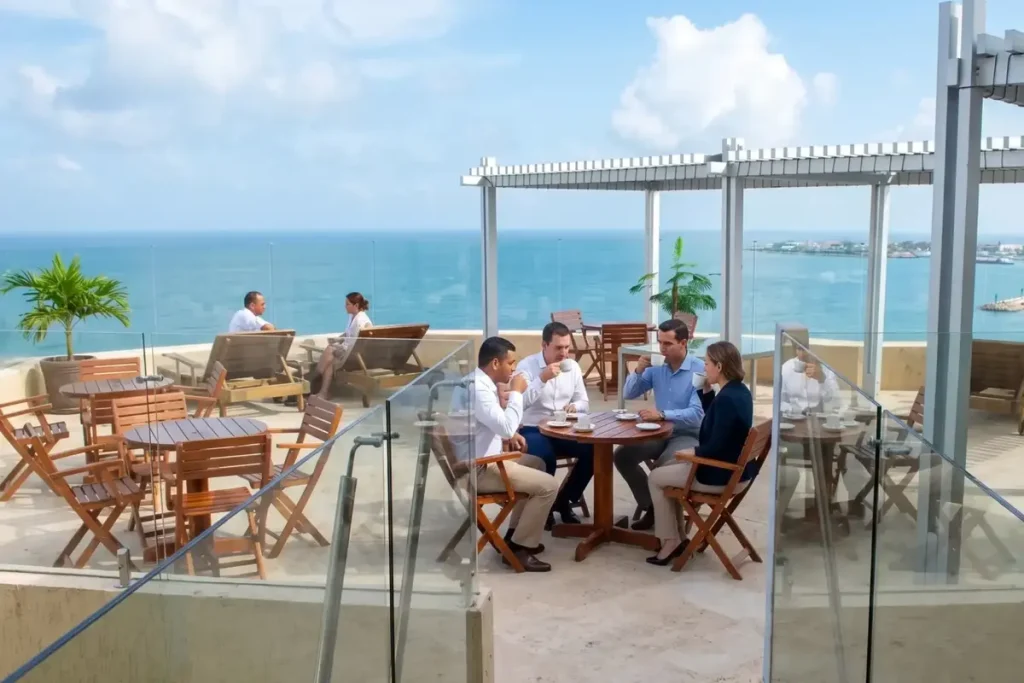 Grupo de ejecutivos en una reunión corporativa en una terraza con vista panorámica al mar en Cartagena.