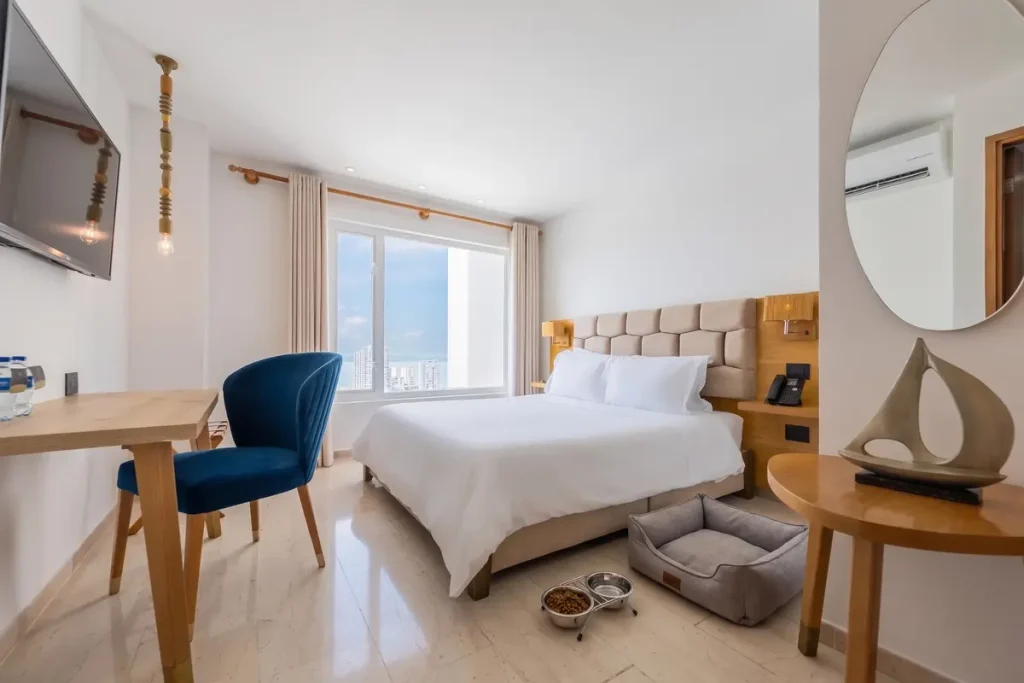 Pet friendly hotel room in Cartagena equipped with a dog bed and food bowls.
