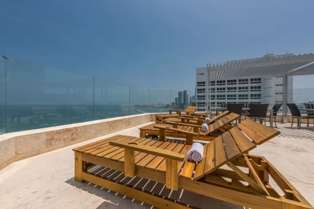Terraza del hotel Regatta soleada con asoleadoras de madera y vista panorámica al mar para disfrutar Cartagena en noviembre.