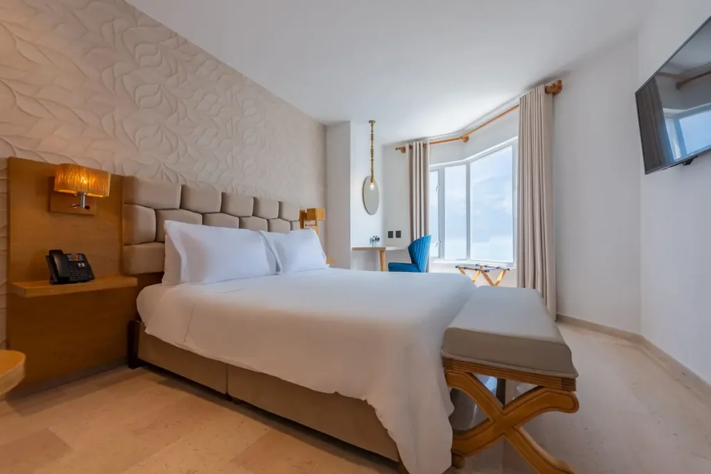 Habitación de hotel Regatta con iluminación natural y vista al mar para hospedarse en Cartagena durante noviembre.
