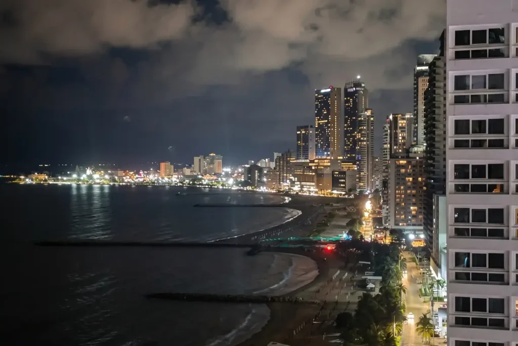 Vista nocturna de los rascacielos y la bahía de Cartagena iluminada para eventos y fiestas empresariales de fin de año.