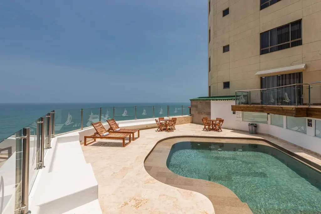 Piscina al aire libre en terraza con asoleadoras y vista al mar en Bocagrande.