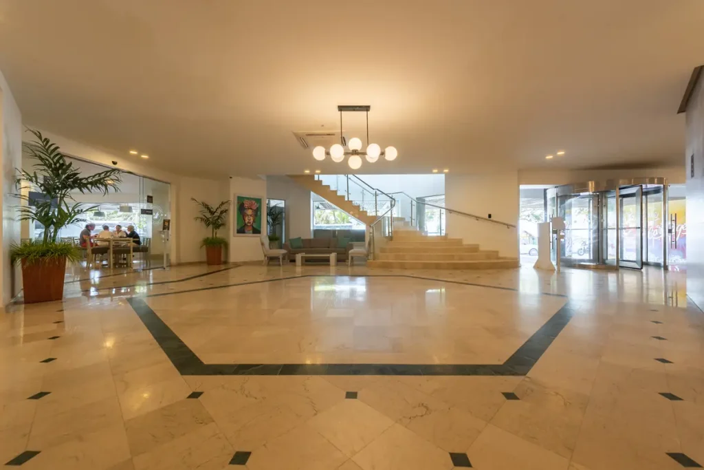 Lobby de entrada con escaleras y decoración elegante en hotel de Cartagena listo para la reserva de estancia.