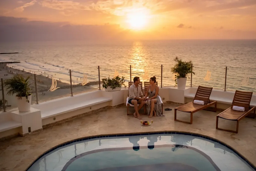 Couple enjoying the ocean sunset from a rooftop pool while traveling to Cartagena in October.